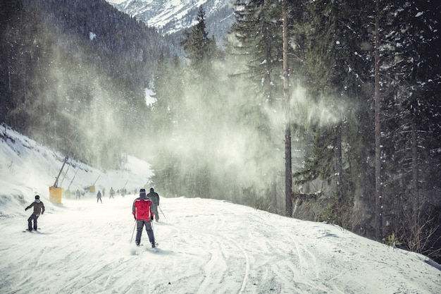 Young man rides snowboard and enjoying a frozen winter day on mountain slopes.