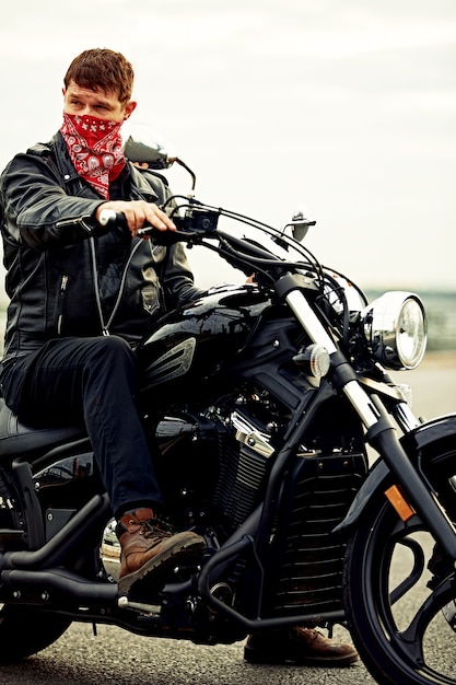 Young man riding big bike ,motorcycle on city road against urban and town building scene