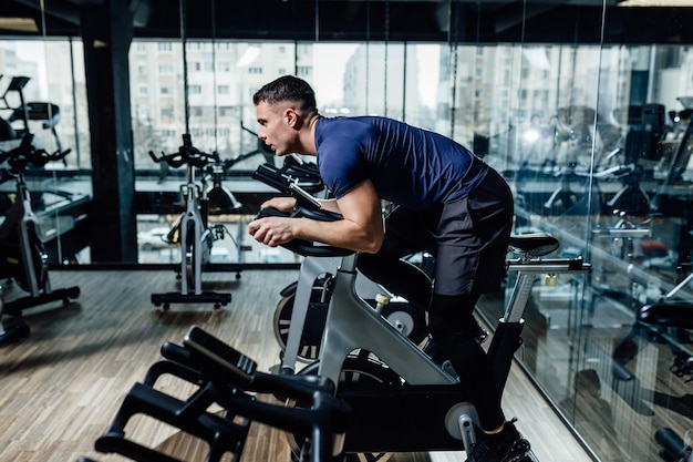 Young man riding an exercise bike.