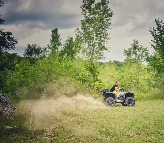 Foto giovane che guida un quad sul campo