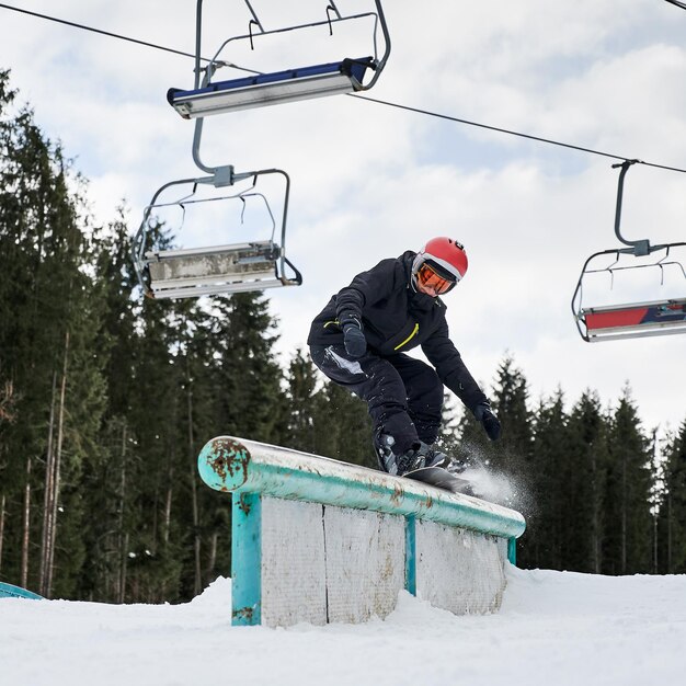 Young man riding snowboard at ski resort