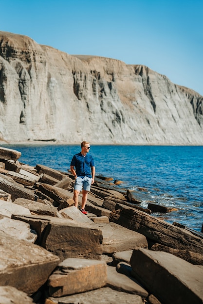 A young man on a rocky beach made of natural stones in the Crimea
