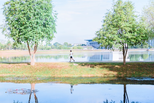 Young man runner athlete running  in a park