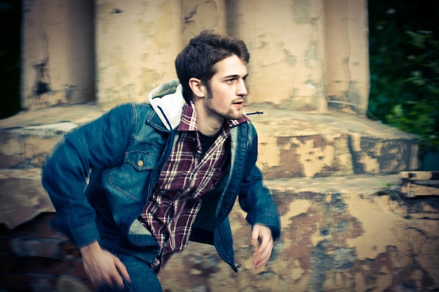 Young man running in front of the ruined wall