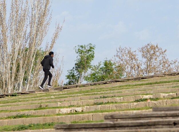 Photo young man running up a wooden stairs outdoors