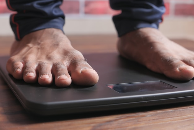 young man's feet on weight scale close up