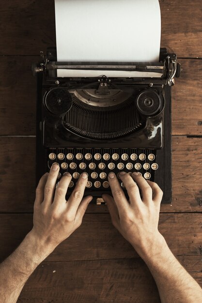 Young man's hands typing on an antique vintage typewriter