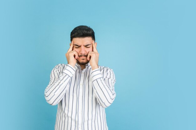 Young man's portrait on blue studio background Concept of human emotions facial expression youth sales ad