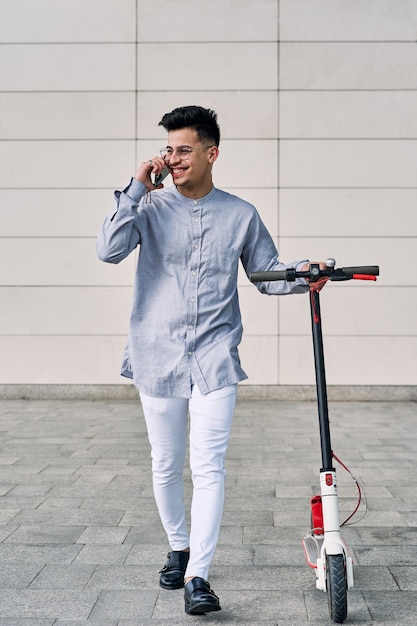 Young man on a scooter talking on the phone