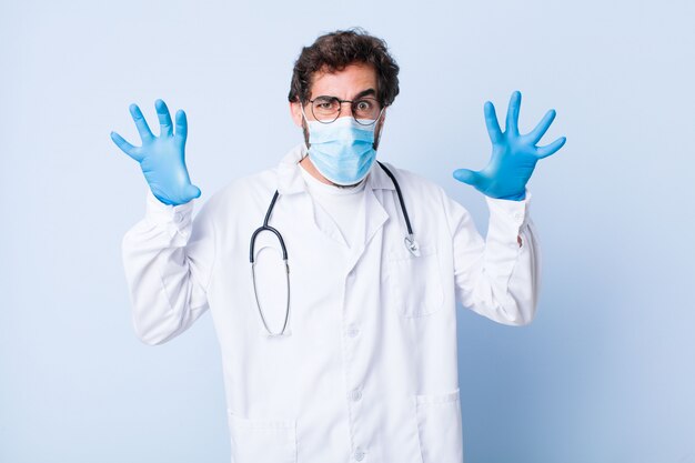 Young man screaming in panic or anger, shocked, terrified or furious, with hands next to head. coronavirus concept