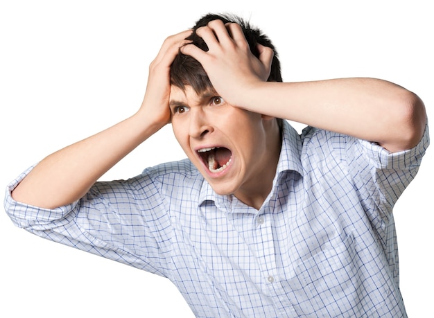 Young man screaming with his hands on his head