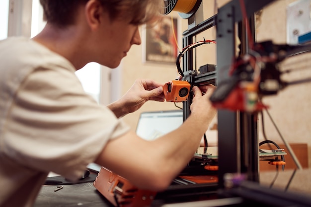 Young man set up d printer