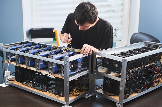 Photo a young man sets up a farm for the extraction of cryptocurrency