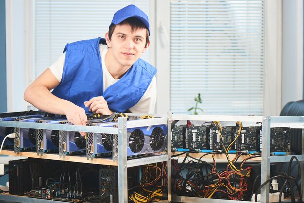 Photo a young man sets up a farm for the extraction of cryptocurrency