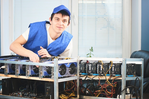 Photo a young man sets up a farm for the extraction of cryptocurrency