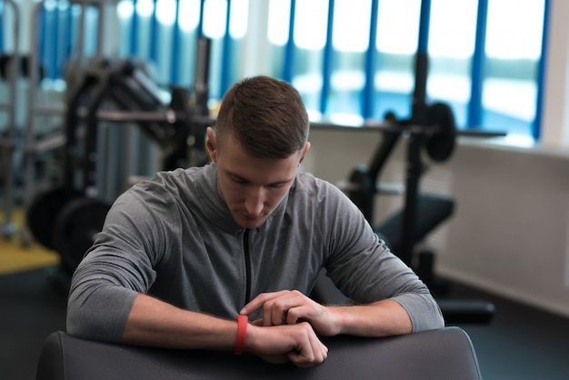 Young Man Setting Activity Tracker in Gym