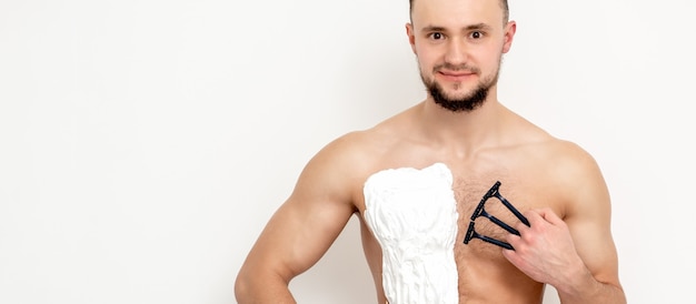 Young man shaving his chest