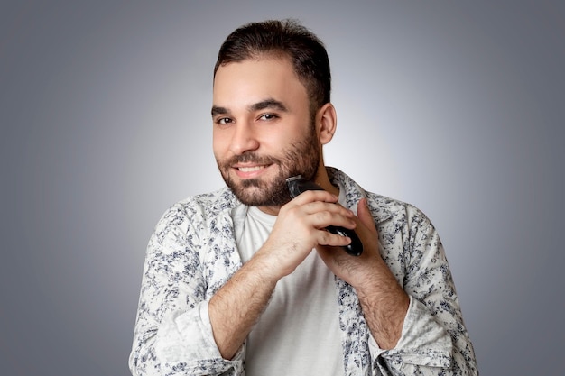 young man shaving his chin while smiling ,isolated background