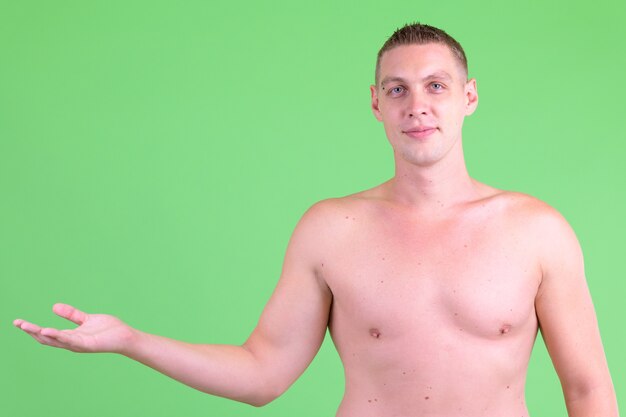 Photo young man shirtless against green wall