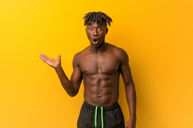 Young man shirtless wearing swimsuit impressed