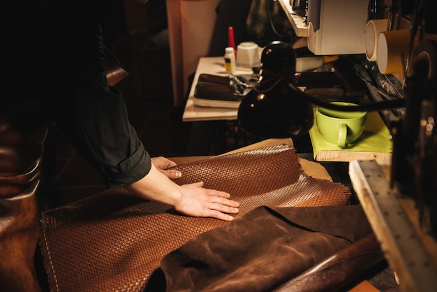 Young man shoemaker at footwear workshop.