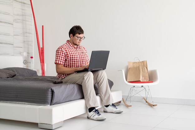 Young man shopping on internet with laptop