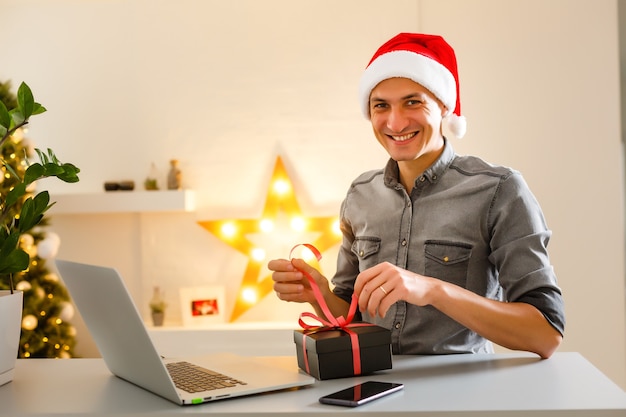 Young man shopping online with credit card at home for Christmas. Christmas shopping concept.