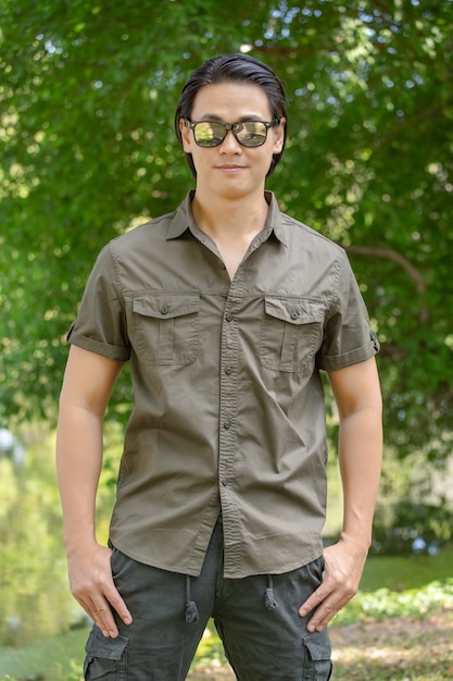 Young man in short sleeve shirt and pants standing  in the park