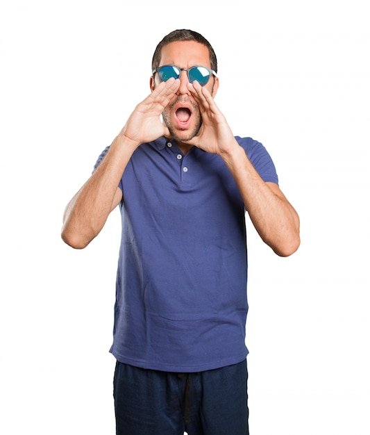 Young man shouting on white background