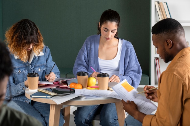 Photo young man showing his friends his notes during study session