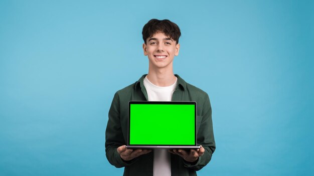 Photo young man showing laptop with green screen
