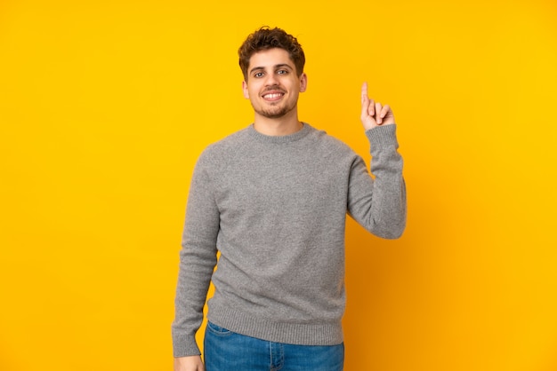 Young man showing and lifting a finger in sign of the best