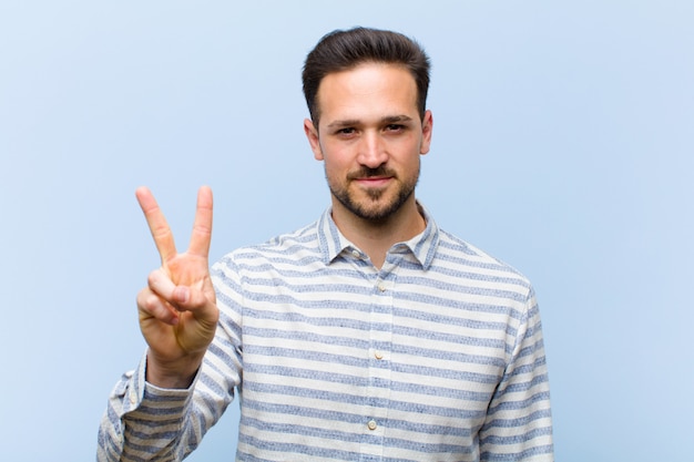 Photo young man showing number two or second with hand forward