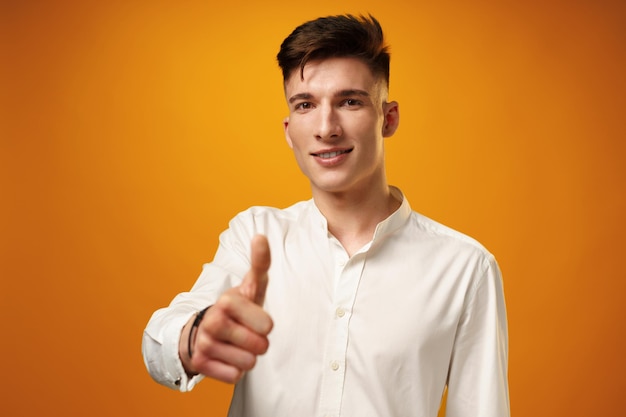 Young man showing ok sign against yellow background