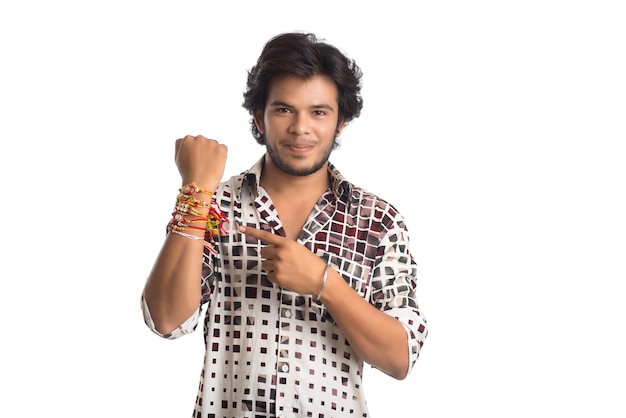 Young man showing rakhi on his hand on an occasion of Raksha Bandhan festival.