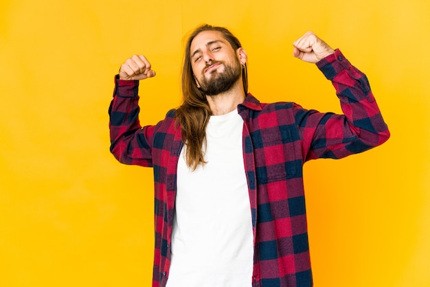 Young man showing strength gesture with arms