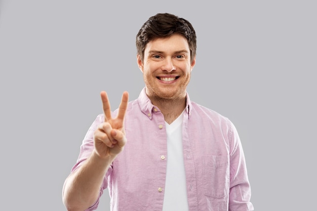 young man showing two fingers or peace hand sign