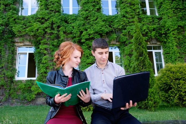 Young man shows laptop to woman