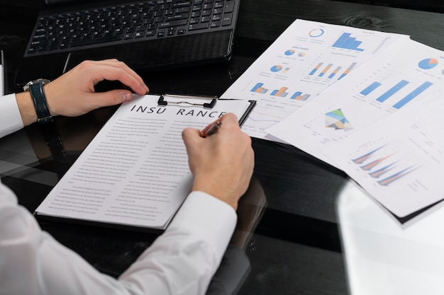 Young man signs insurance in bright office