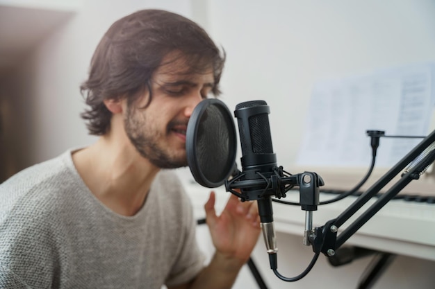 Young man singing and feeling the music concentrated