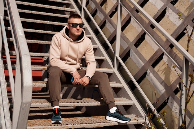 A young man sits on the steps in the city urban style lifestyle photo