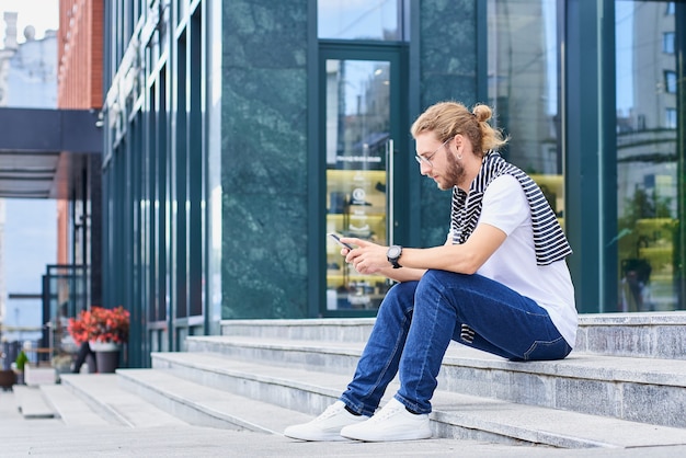 若い男が階段を待って座っている