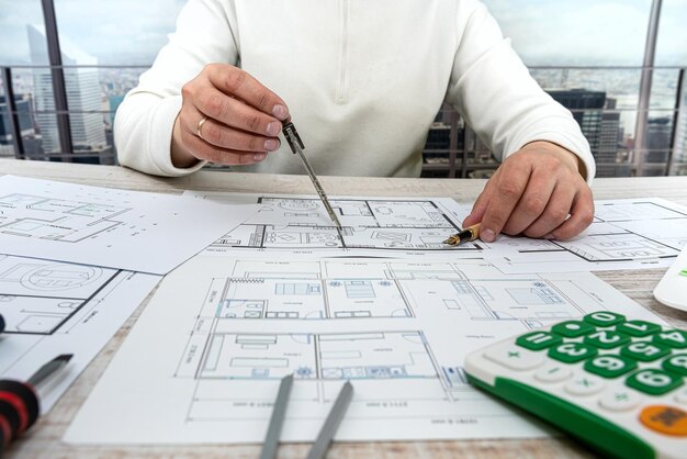 Young man sitting according to the drawings of a new house project