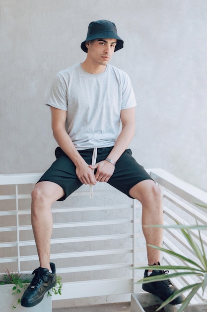 壁に寄りかかって座っている若い男
