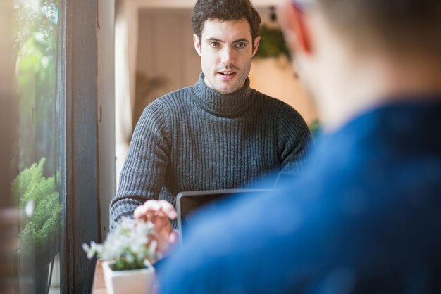 写真 レストランのテーブルに座っている若い男