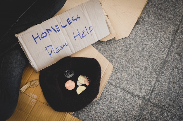 Young man sitting begging in the capita