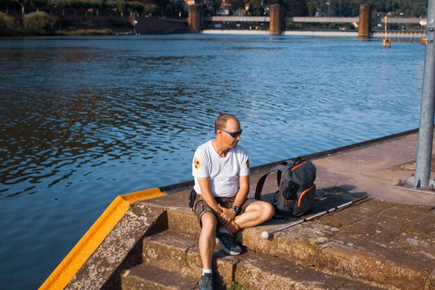 Young man sitting by lake