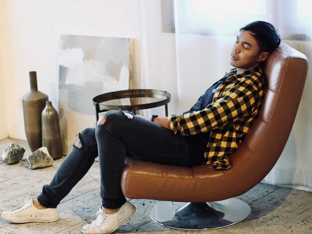 Young man sitting on chair at home