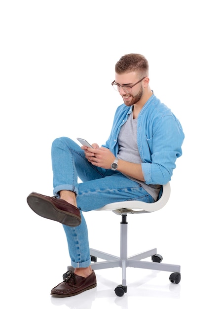 Young man sitting on chair and using mobile phone Startupper Young entrepreneur