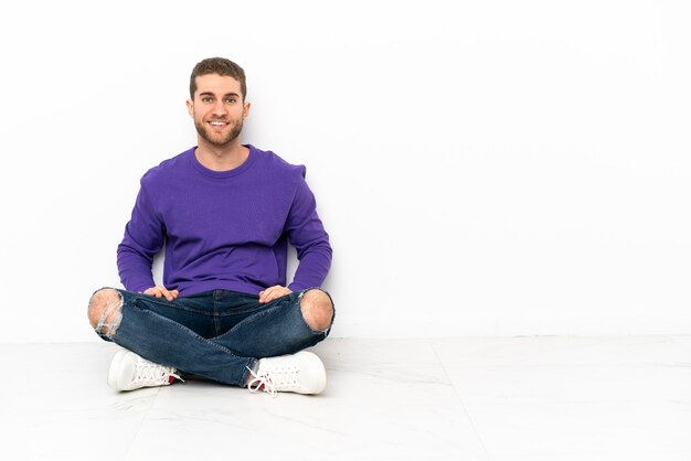 Photo young man sitting on the floor laughing